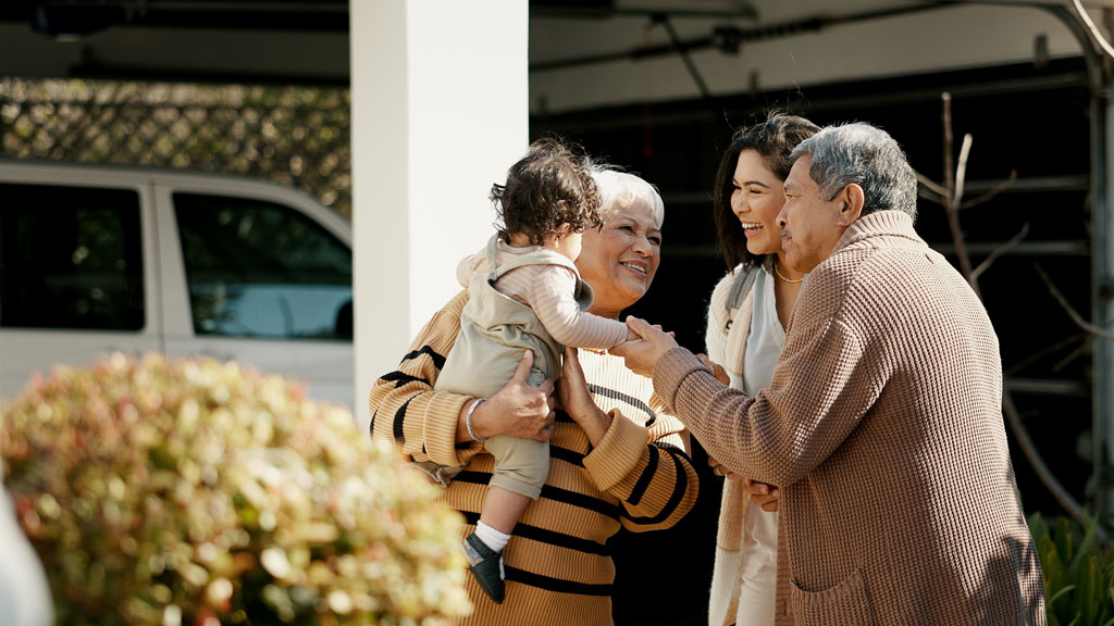 Famille en visite dans le jardin d'un établissement pour seniors
